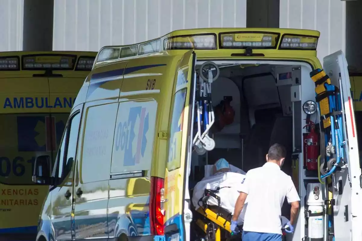 Un profesional sanitario baja de una ambulancia en camilla a un paciente que ha sido trasladado en Galicia (España)