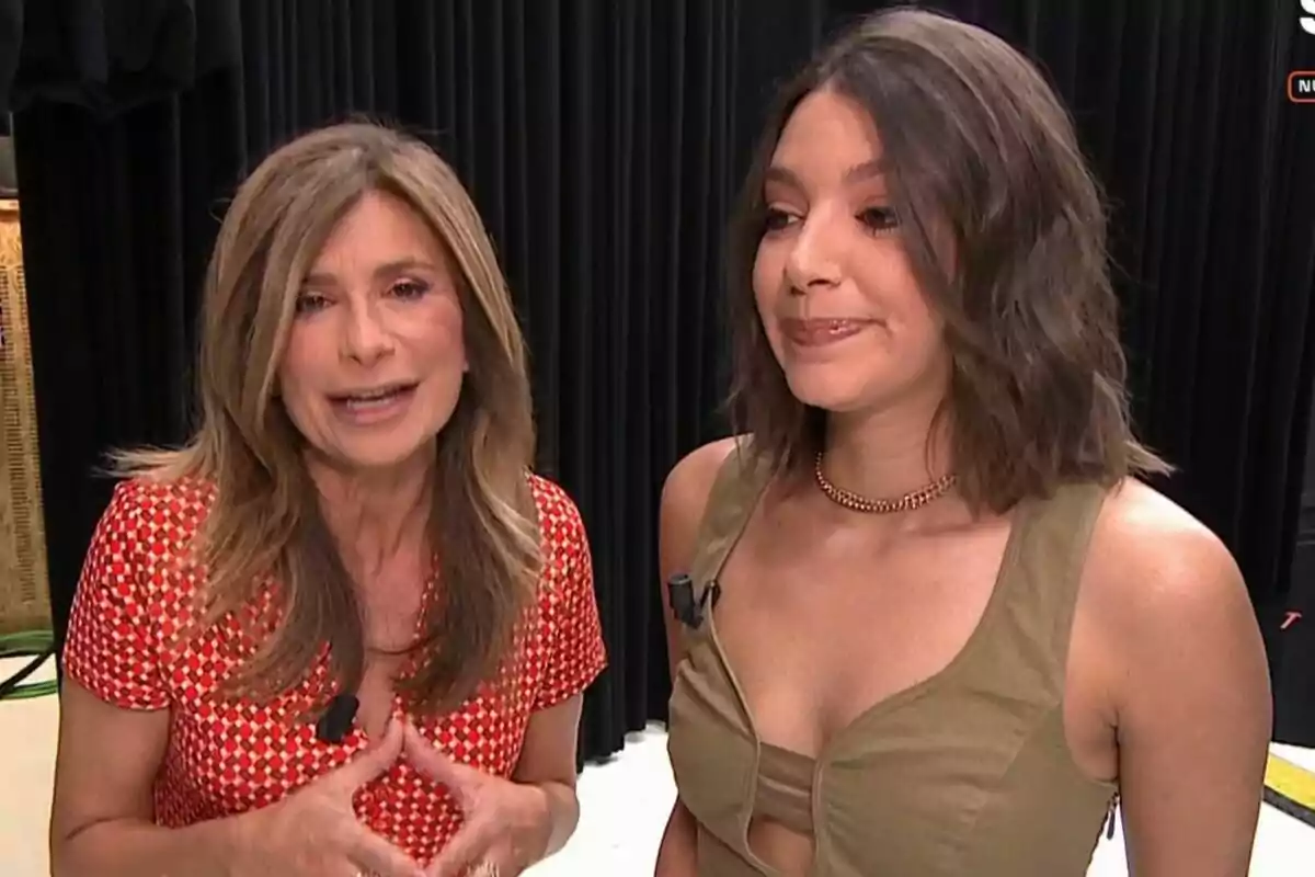 Gema López y Ana Guerra posan juntas frente a un fondo de cortinas negras, una lleva un vestido rojo con estampado y la otra un top marrón en Espejo Público. Gema López y Ana Guerra posan juntas frente a un fondo de cortinas negras, una lleva un vestido rojo con estampado y la otra un top marrón en Espejo Público.