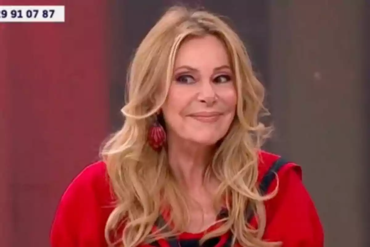 Ana Obregón rubia con cabello largo y ondulado, vestida de rojo y sonriendo mientras mira hacia un lado en 'Y ahora Sonsoles'.