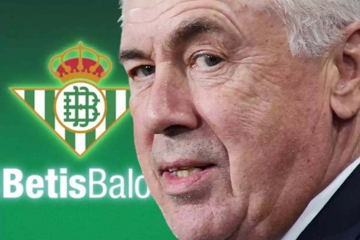 Hombre mayor con cabello canoso frente al logo del Real Betis Balompié.