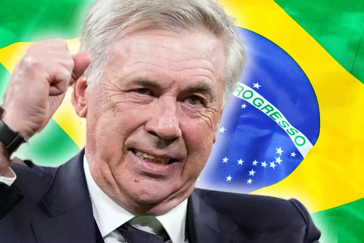 Un hombre de cabello canoso y traje oscuro levanta el puño frente a una bandera de Brasil.