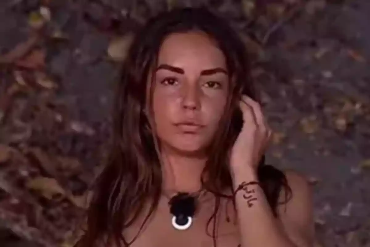 Primer plano de Anita Williams con cabello largo y oscuro mientras está en 'Supervivientes' con un fondo de hojas secas.