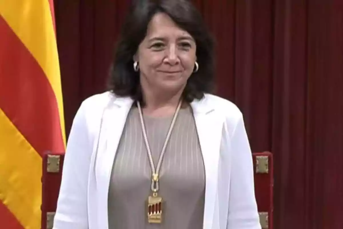 Foto a medio cuerpo de Anna Erra, de pie, con la medalla de presidenta del Parlament de Cataluña