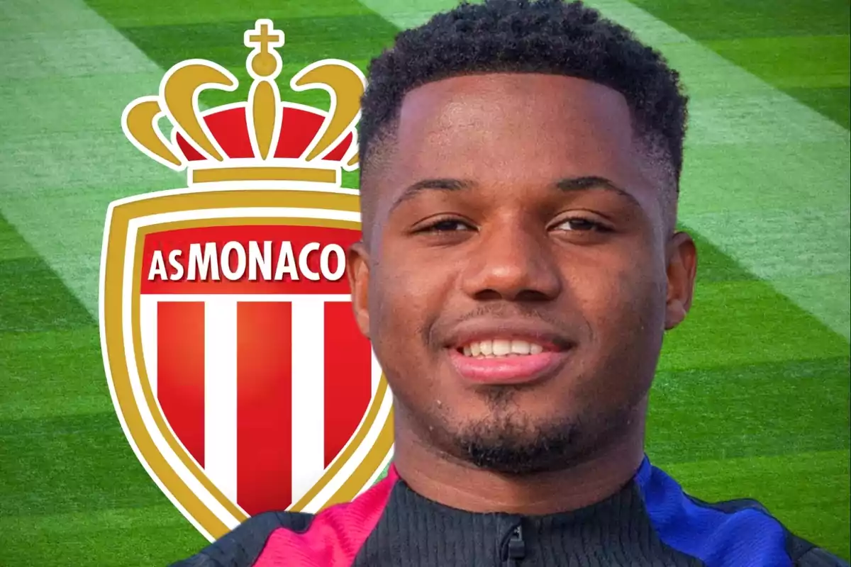 Un futbolista sonriente con el escudo del AS Monaco de fondo sobre un campo de césped.