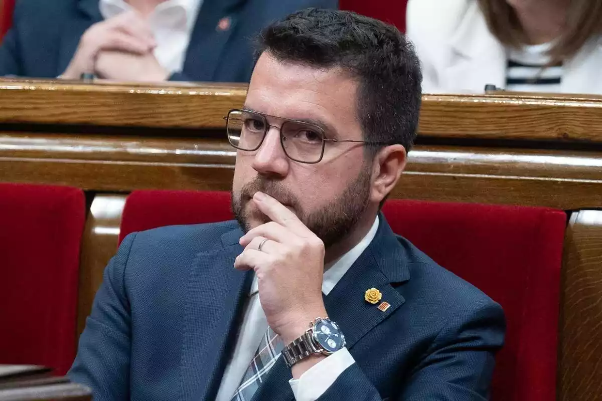 Imagen de Pere Aragones con la mano en la barbilla, sentado en su escaño del parlament de cataluña
