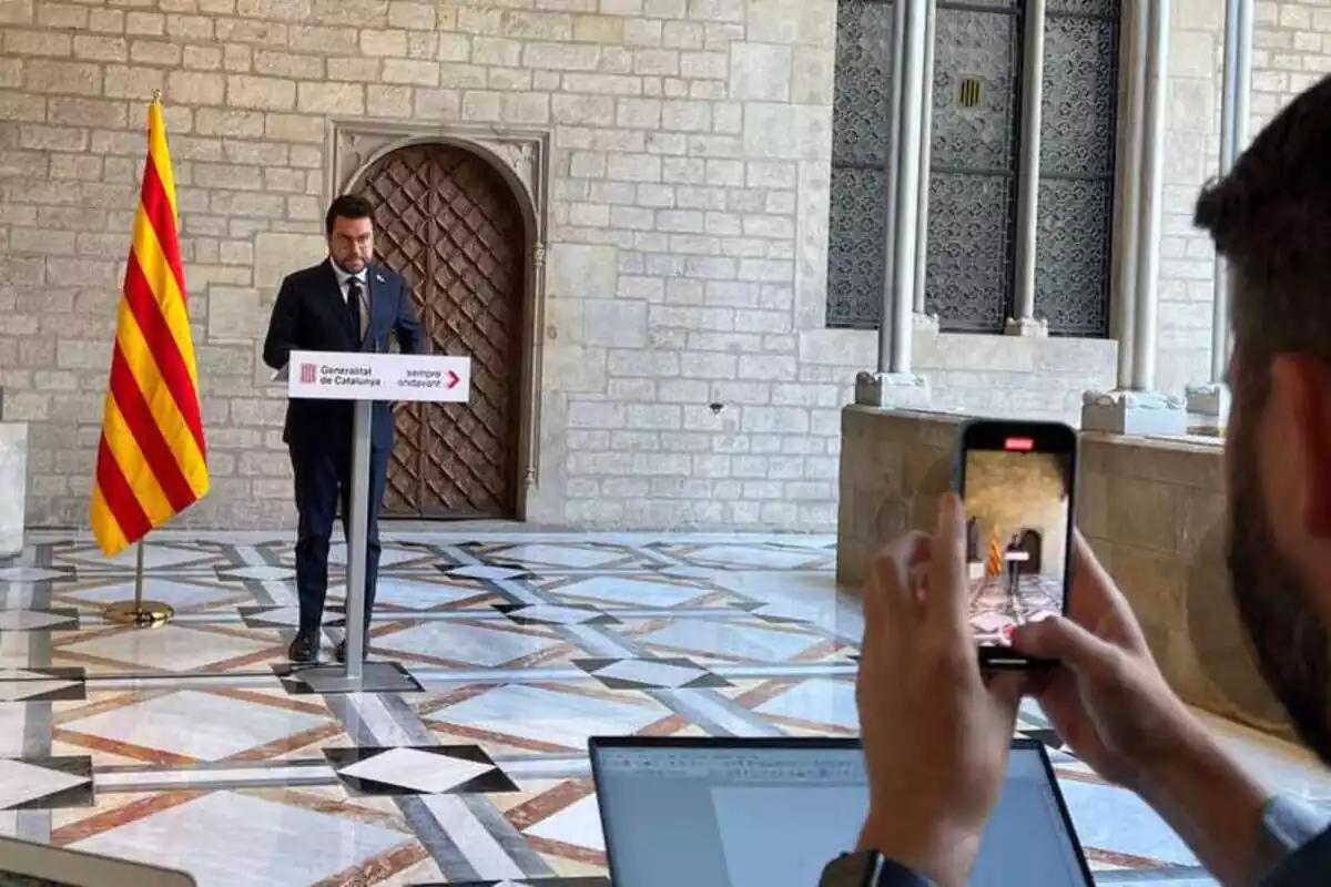 Imagen del presidente Pere Aragonès en el Palau de la Generalitat con un periodista sacando una foto