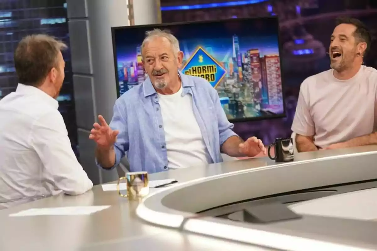 Pablo Motos, Karlos y Joseba Arguiñano conversan y ríen sentados alrededor de una mesa en un plató de televisión con el logo de 'El Hormiguero' en una pantalla de fondo Pablo Motos, Karlos y Joseba Arguiñano conversan y ríen sentados alrededor de una mesa en un plató de televisión con el logo de 'El Hormiguero' en una pantalla de fondo