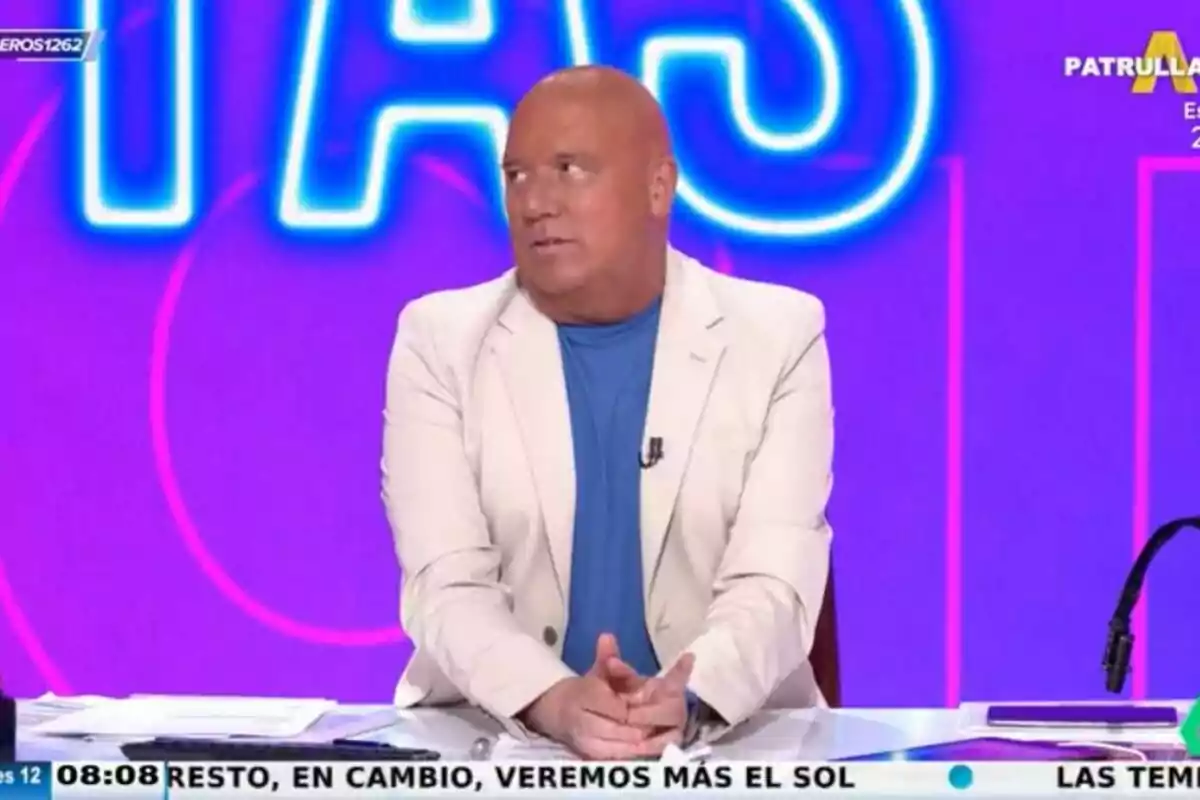 Captura de 'Aruser@s' con Alfonso Arús mirando a un lado en un traje blanco y camiseta azul el 12 de junio de 2024