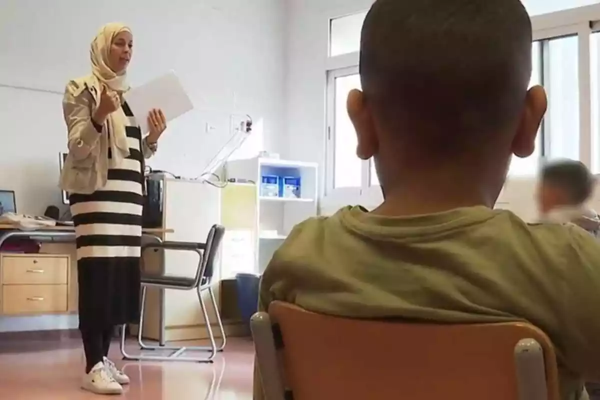 Captura de una clase de islam en una escuela de Mallorca en la que sale una profesora impartiendo clase vestida con velo islámico y en primer plano un niño de espaldas siguiendo sus indicaciones