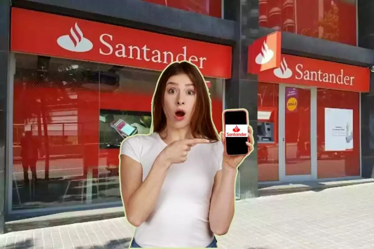 Una mujer sorprendida señala un teléfono móvil con el logo de Santander frente a una sucursal del banco.