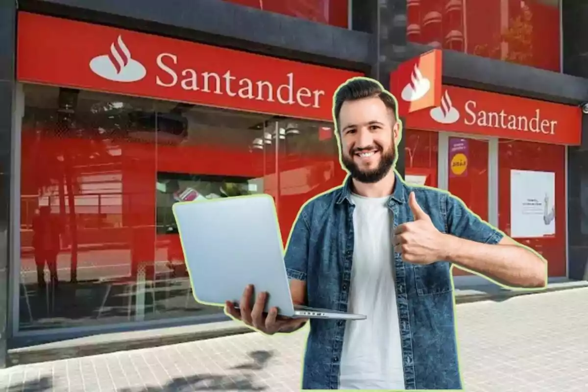 Hombre sonriente con laptop frente a una sucursal de Santander.