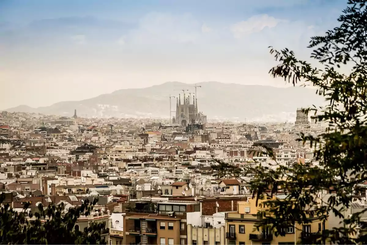 Vista panorámica de la ciudad de Barcelona con la Sagrada Familia al fondo y montañas en el horizonte