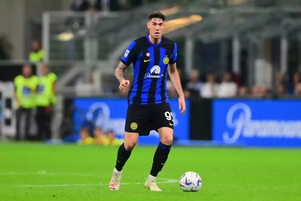 Jugador de fútbol con uniforme negro y azul en el campo de juego con un balón a sus pies. Jugador de fútbol con uniforme negro y azul en el campo de juego con un balón a sus pies.