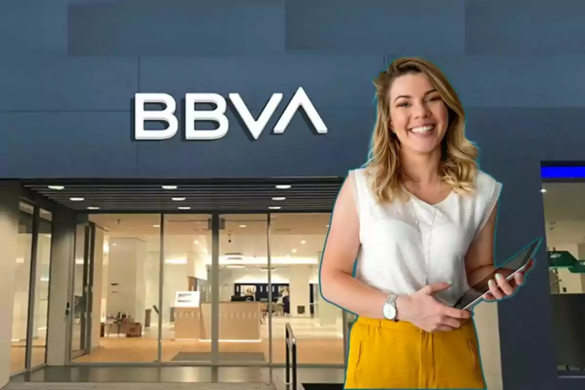 Mujer sonriendo frente a una sucursal de BBVA.