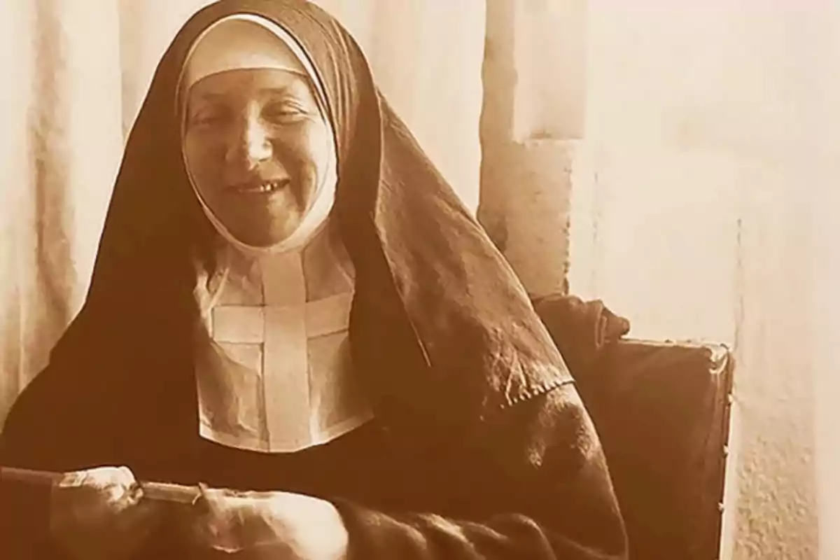Una monja sonriente con hábito religioso en una fotografía antigua. Una monja sonriente con hábito religioso en una fotografía antigua.