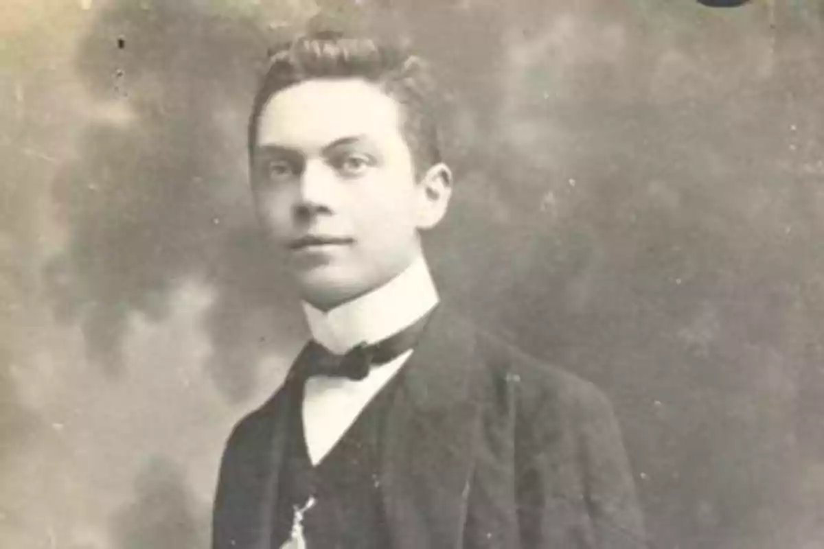 Joven con traje elegante y pajarita en una fotografía antigua en blanco y negro Joven con traje elegante y pajarita en una fotografía antigua en blanco y negro