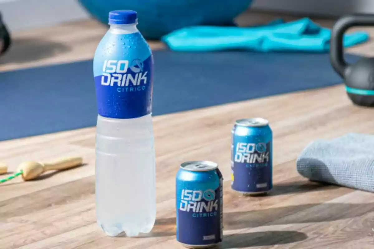 Una botella y dos latas de bebida isotónica con la etiqueta Una botella y dos latas de bebida isotónica con la etiqueta