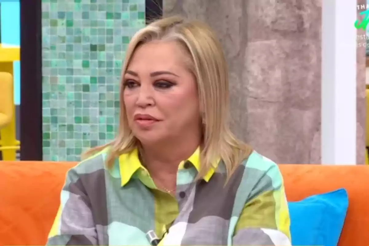 Belén Esteban, con camisa de colores, sentada en un sofá naranja en el programa 'La familia de la tele'