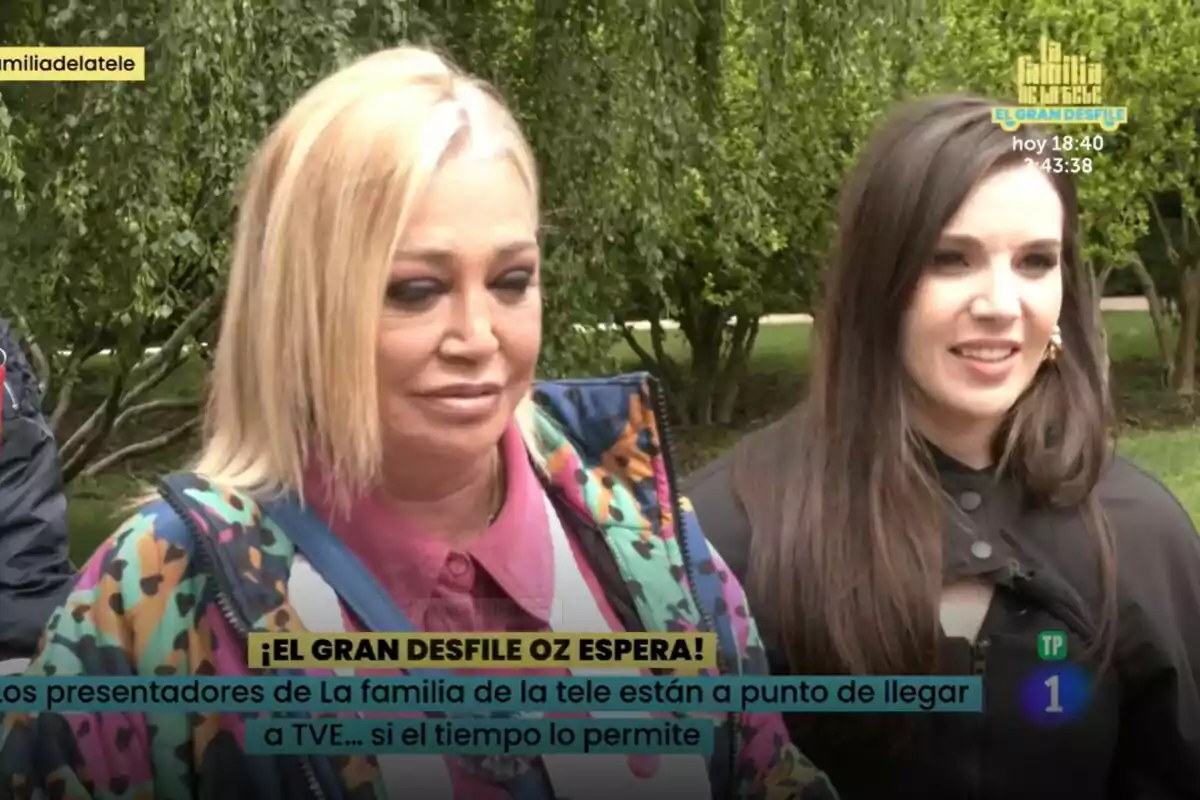 Belén Esteban e Inés Hernand están al aire libre, una con cabello rubio y chaqueta colorida, y la otra con cabello oscuro, ambas sonriendo en La Familia de la Tele. En la imagen hay texto que menciona un desfile y un programa de televisión. Belén Esteban e Inés Hernand están al aire libre, una con cabello rubio y chaqueta colorida, y la otra con cabello oscuro, ambas sonriendo en La Familia de la Tele. En la imagen hay texto que menciona un desfile y un programa de televisión.