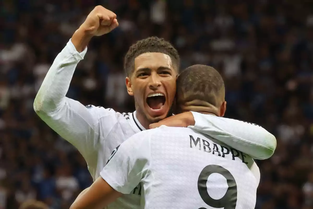 Dos jugadores de fútbol celebrando un gol en un estadio