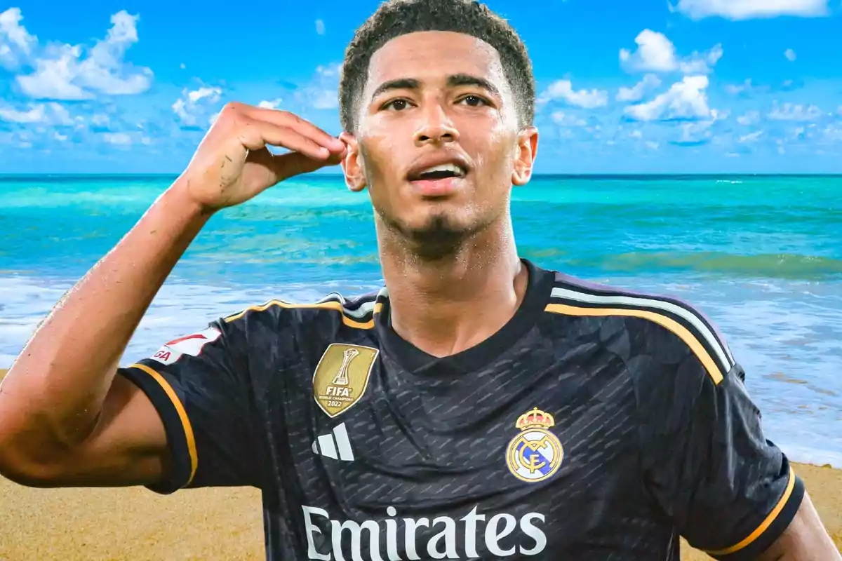 Un jugador de fútbol con la camiseta del Real Madrid celebrando en una playa con el mar y el cielo azul de fondo.