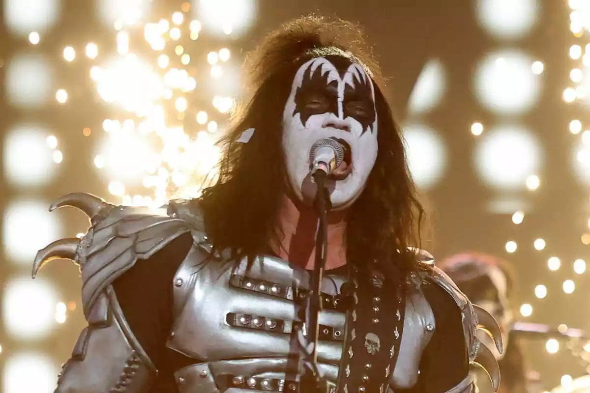Bertín Osborne con maquillaje facial blanco y negro y un traje metálico canta en el escenario rodeado de luces brillantes en Tu Cara Me Suena.