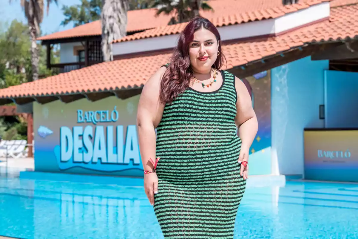 Blanca Martínez con vestido de rayas verdes y negras posando junto a una piscina con un letrero de Barceló Desalia al fondo Blanca Martínez con vestido de rayas verdes y negras posando junto a una piscina con un letrero de Barceló Desalia al fondo