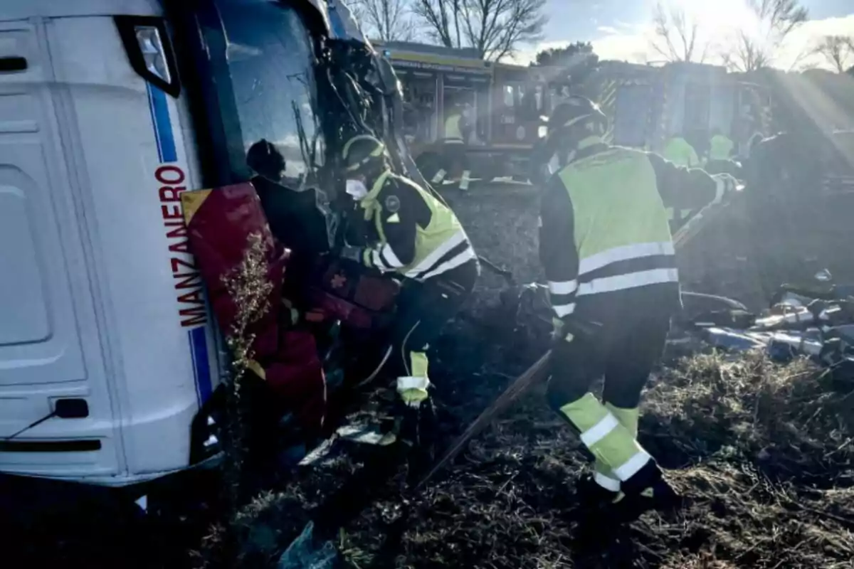 Un grupo de bomberos trabaja en el rescate de un autobús volcado en un área rural.