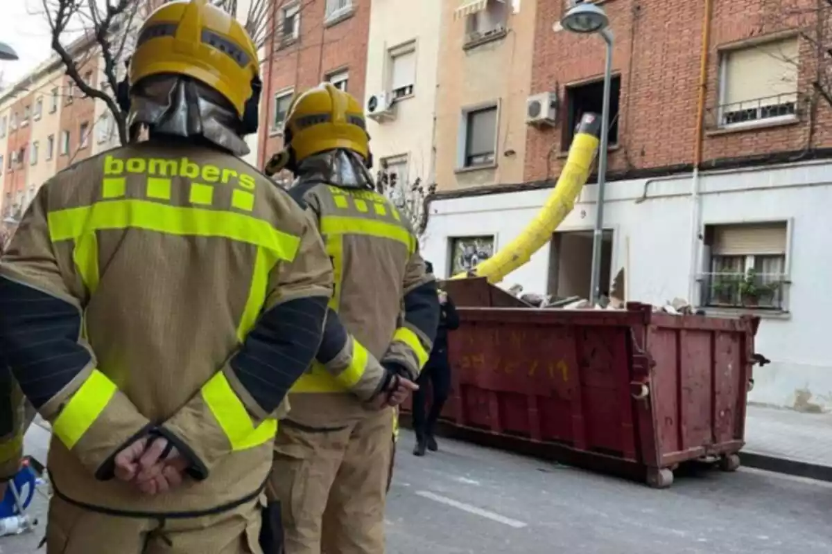 Dos bomberos junto al edificio derrumbado de Badalona