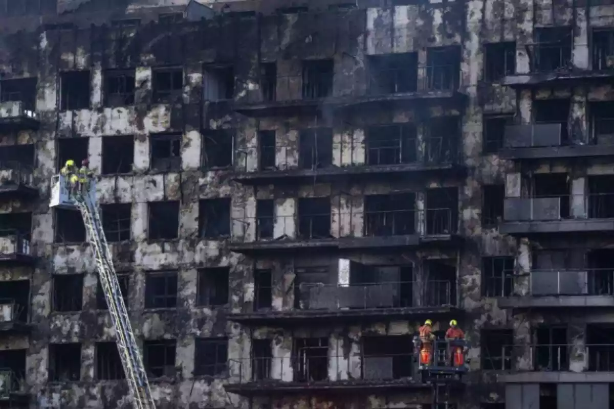 Bomberos subidos en grúas delante del edificio incendiado en Valencia Bomberos subidos en grúas delante del edificio incendiado en Valencia