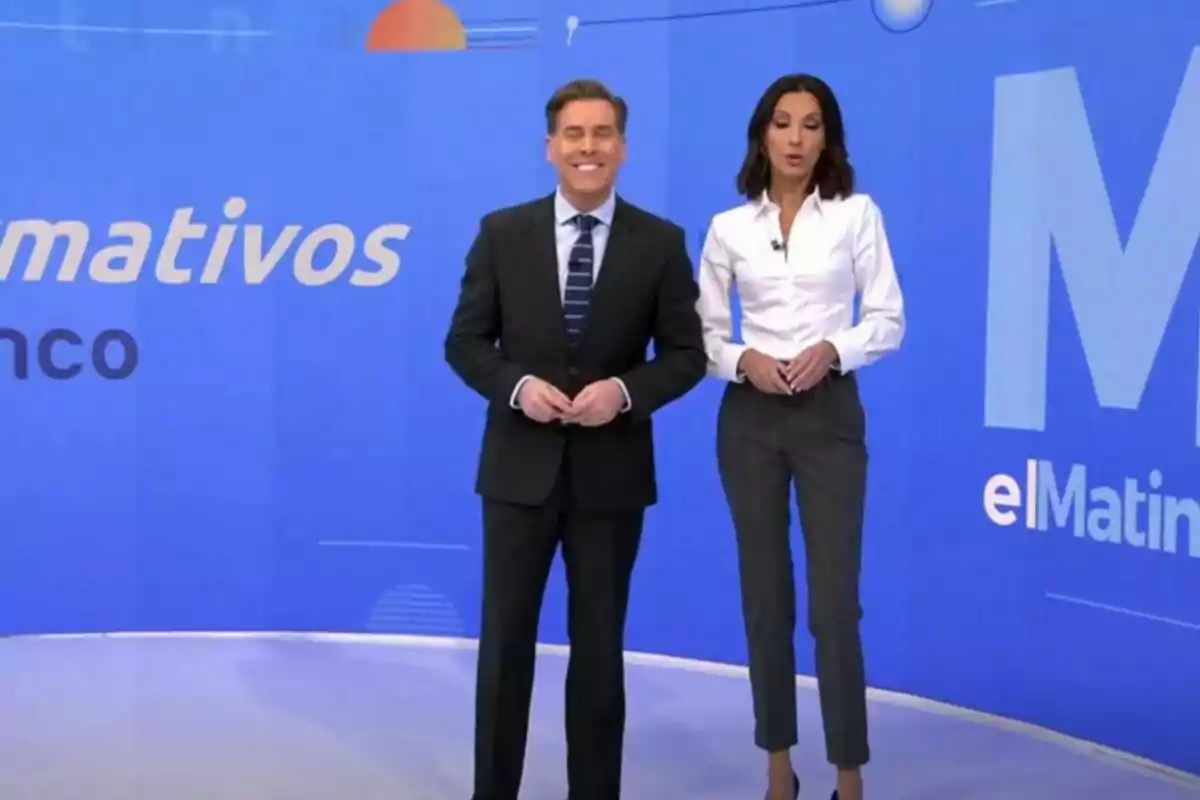 Bricio Segovia y Laila Jiménez de pie en el plató de Informativos Telecinco con un fondo azul que muestra el nombre del programa. Bricio Segovia y Laila Jiménez de pie en el plató de Informativos Telecinco con un fondo azul que muestra el nombre del programa.