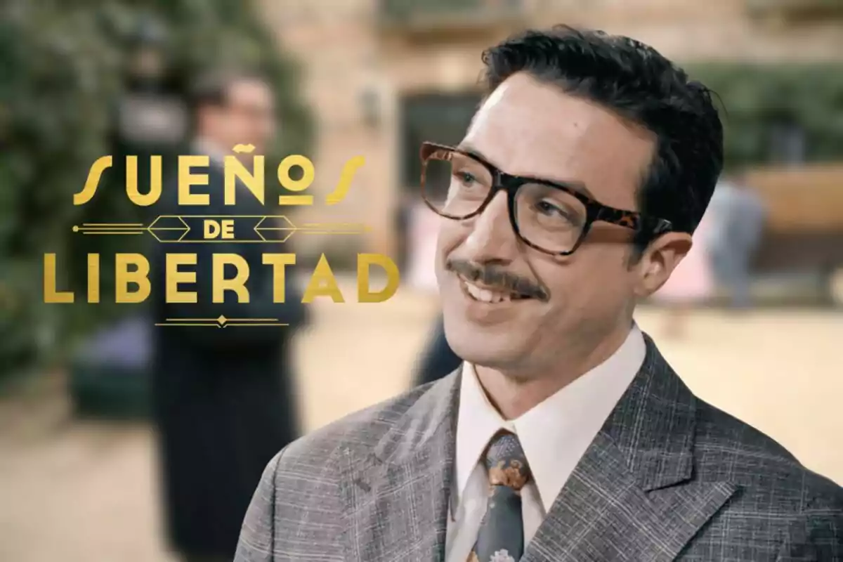 Bruno Tamarit con gafas y bigote sonríe mientras lleva traje y corbata, junto al texto Sueños de Libertad en letras doradas