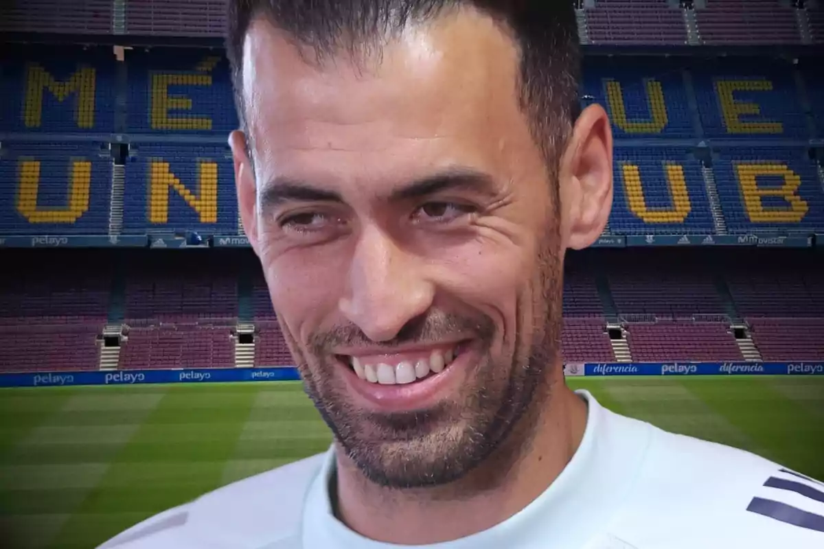 Un hombre sonriente en un estadio de fútbol.