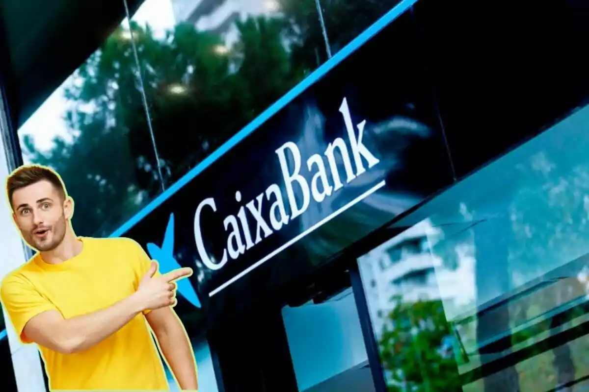 Un hombre con camiseta amarilla señala hacia un letrero de CaixaBank.