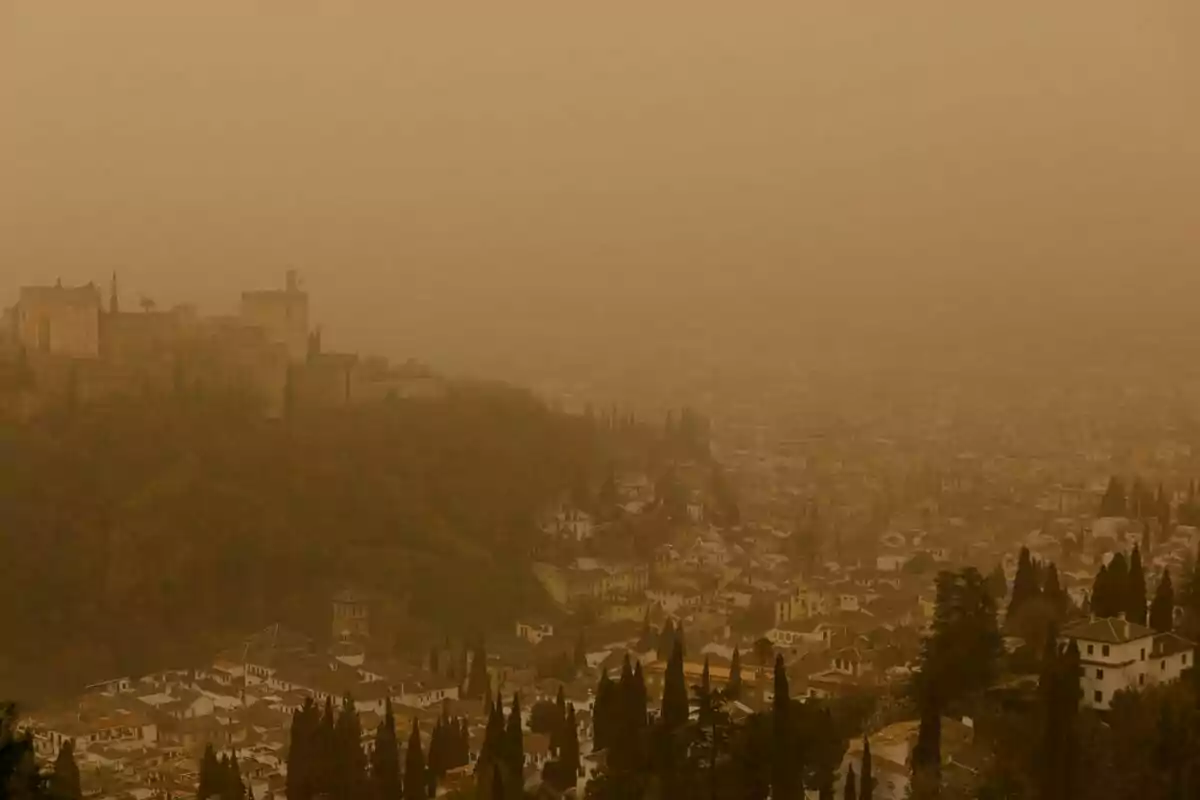 Vista de una ciudad con un castillo en una colina bajo una densa capa de polvo o neblina. Vista de una ciudad con un castillo en una colina bajo una densa capa de polvo o neblina.