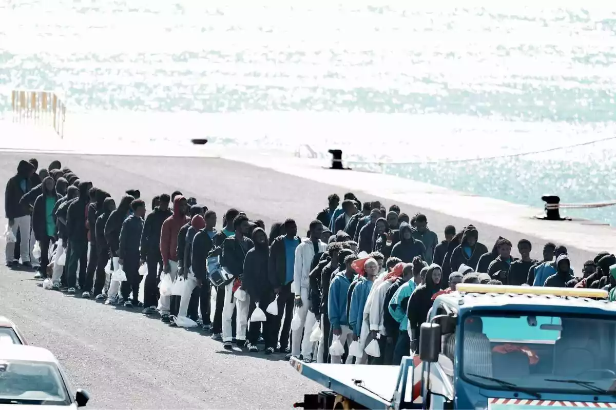 Imagen de un cayuco en aguas canarias con decenas de inmigrantes ilegales con impermeable