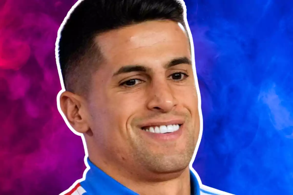 Joao Cancelo con una gran sonrisa delante de un fondo de color azul y morado