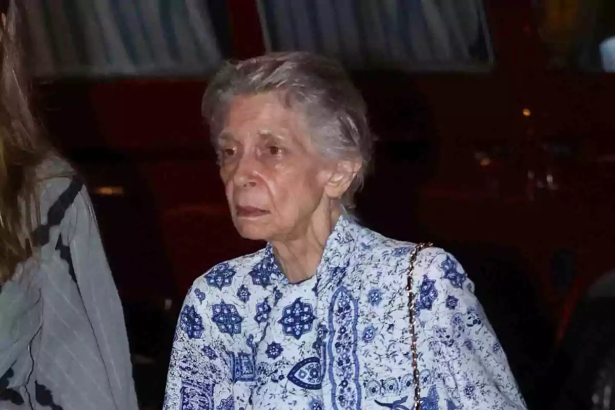 Irene de Grecia con cabello canoso y corto lleva una blusa con estampado azul y blanco mientras camina por la calle. Irene de Grecia con cabello canoso y corto lleva una blusa con estampado azul y blanco mientras camina por la calle.