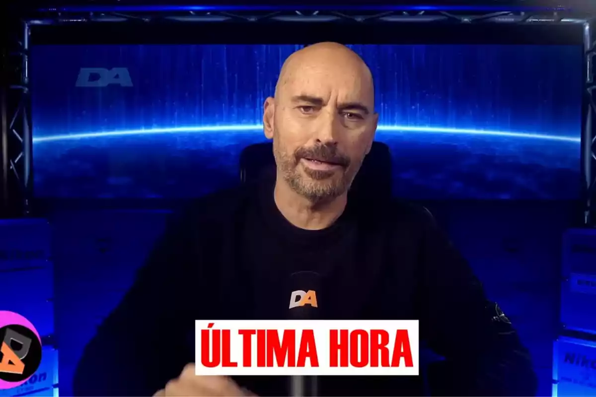 Diego Arrabal con barba está hablando frente a un micrófono con el logotipo Diego Arrabal con barba está hablando frente a un micrófono con el logotipo