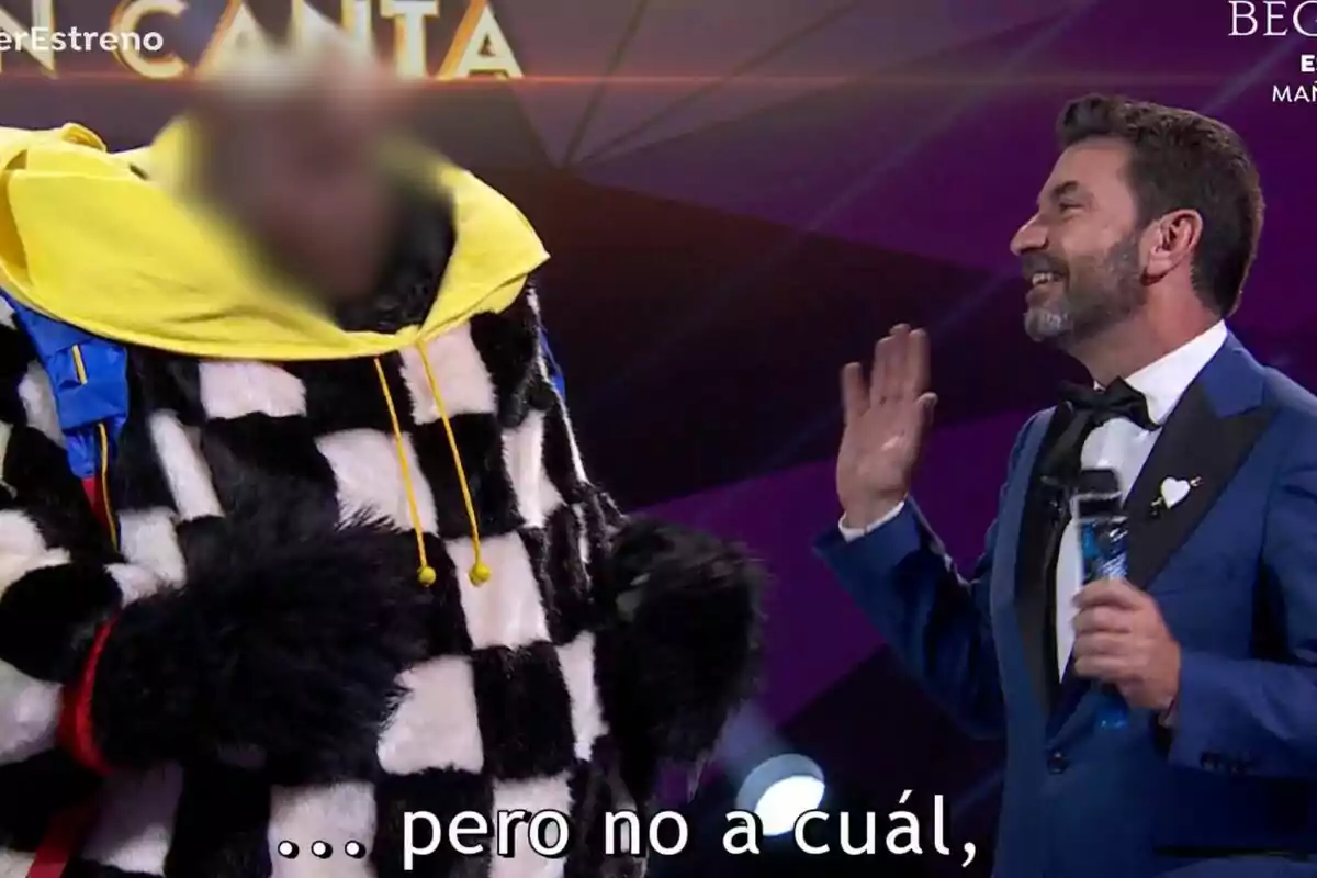 Arturo Valls sonriente interactúa con una Carl Lewis disfrazada en Mask Singer.