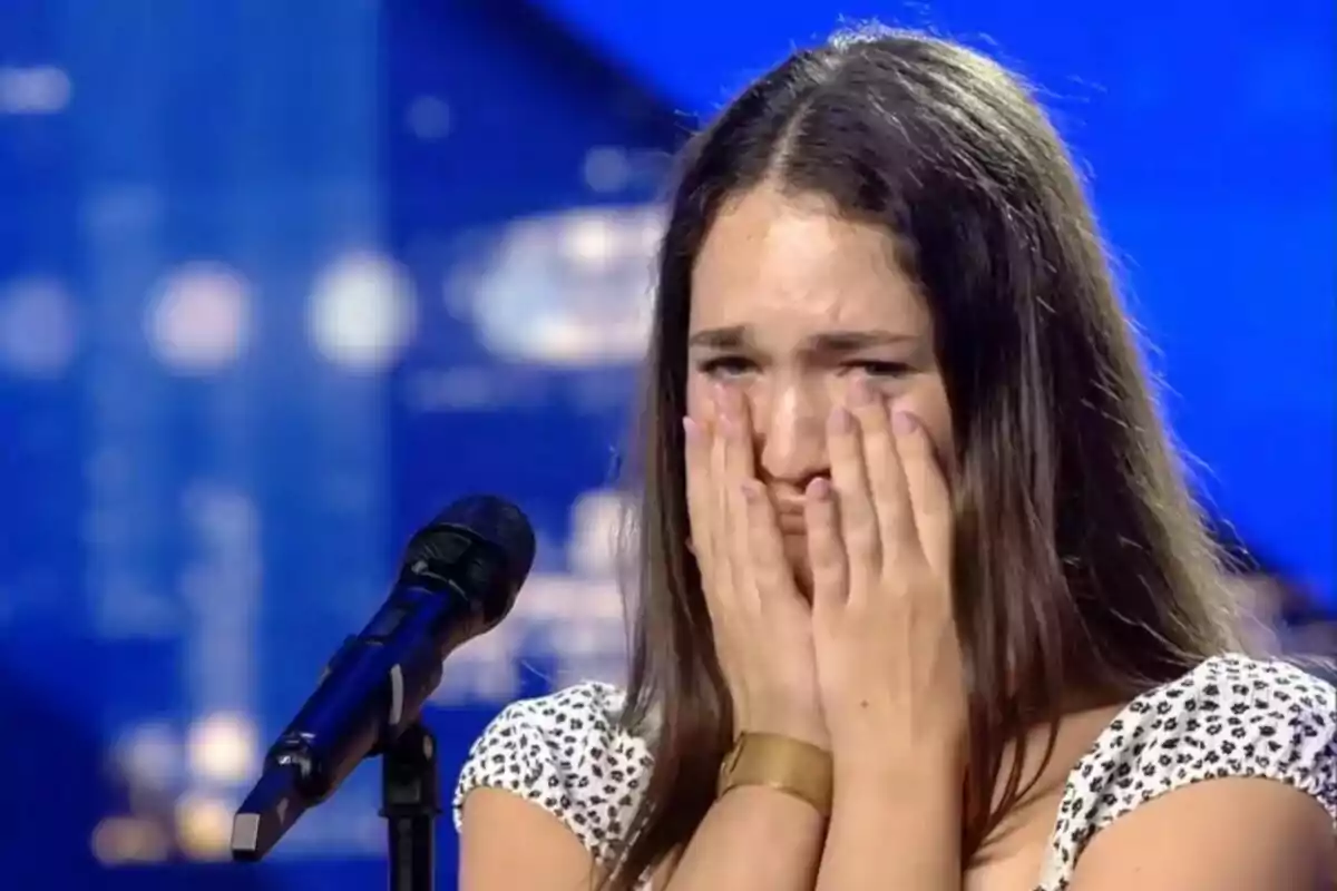 Una joven llamada Carla emocionada con las manos en la cara frente a un micrófono en el escenario de Got Talent.