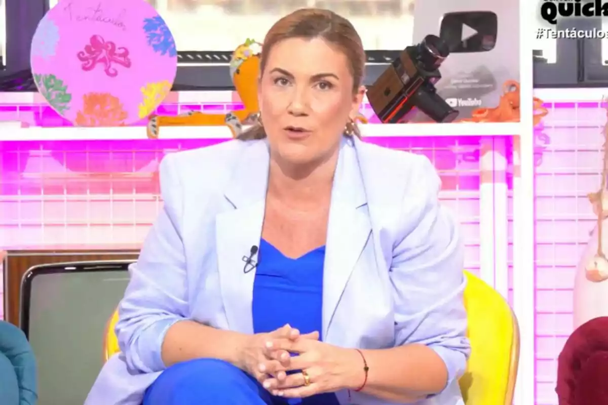 Carlota Corredera sentada en un sillón amarillo con fondo colorido y objetos decorativos en 'Tentáculos'.