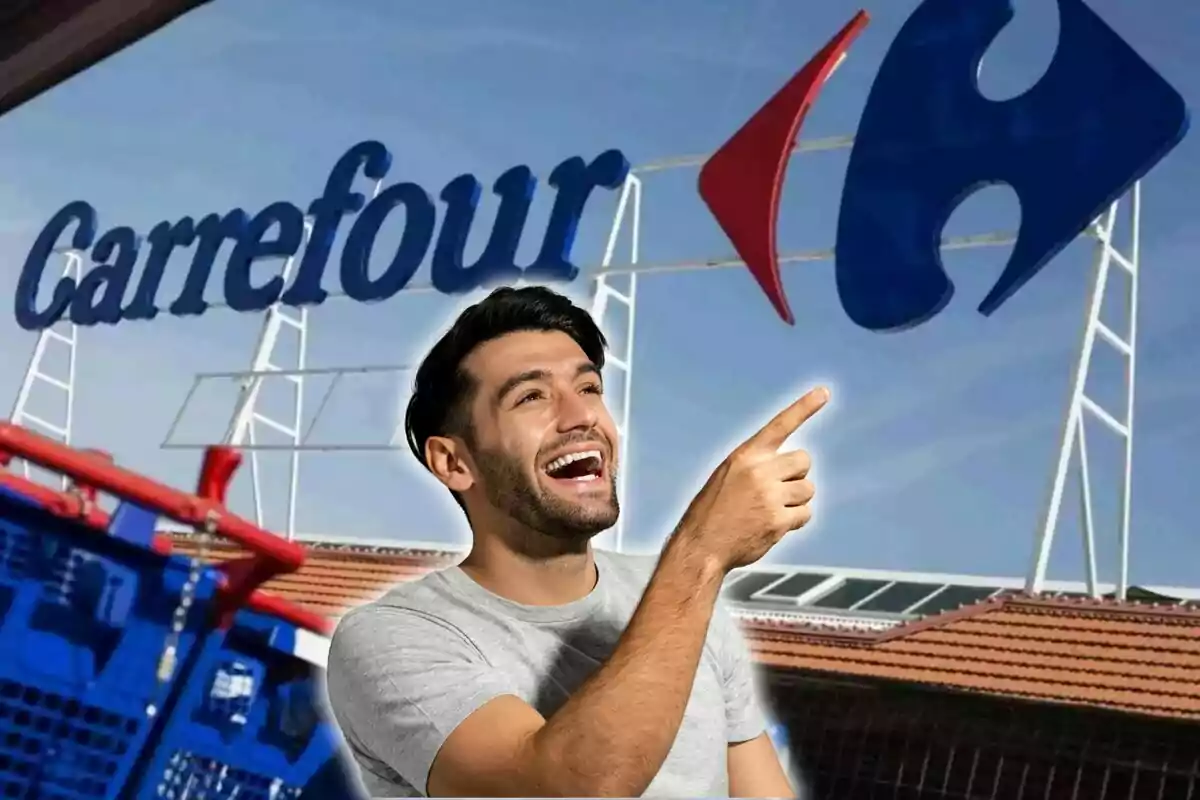 Un hombre sonriente señala hacia el logotipo de Carrefour en el exterior de una tienda.