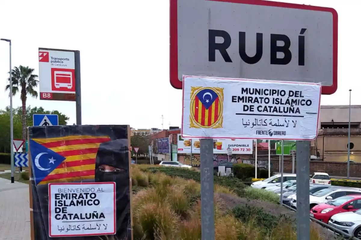 Cartel de la entrada a Rubí, un pueblo de Cataluña, con el nombre borrado y con carteles que indican que es un 'emirato islámico de Cataluña'