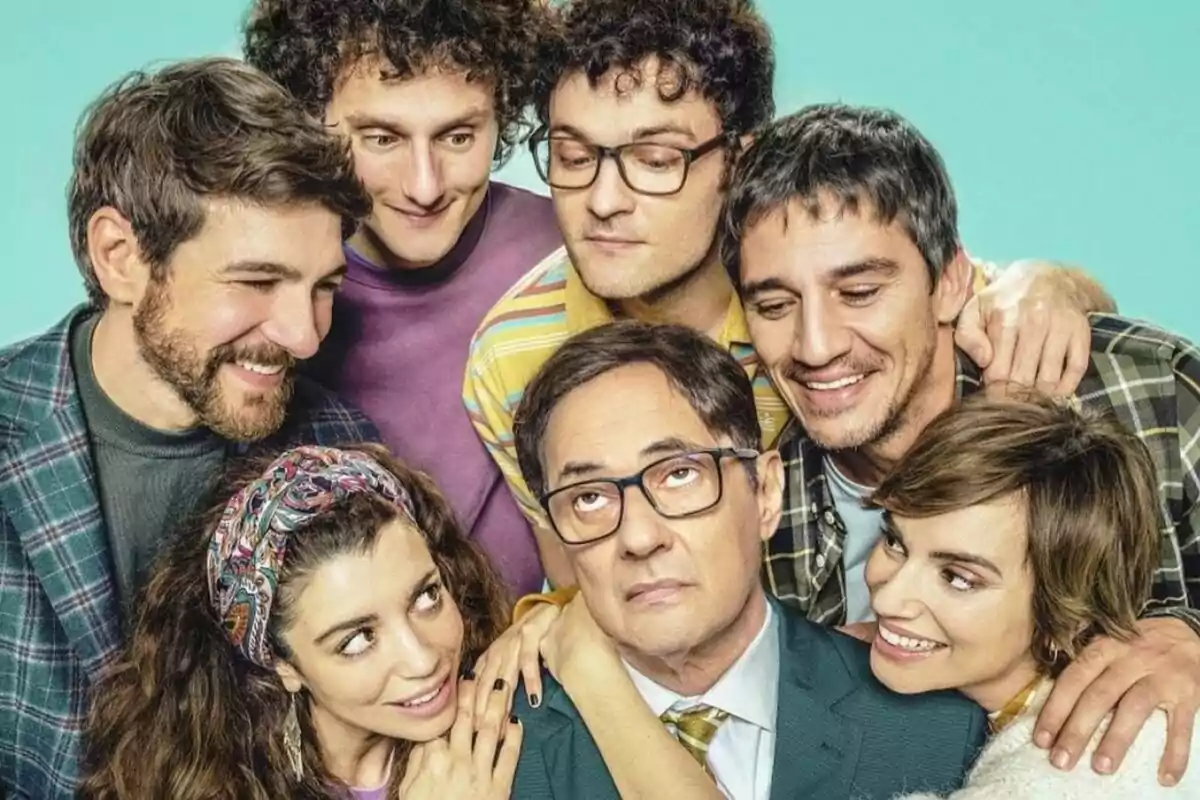 Un grupo de personas sonrientes rodea a Jordi Sánchez con gafas que tiene una expresión seria en el cartel de Señor, dame paciencia.