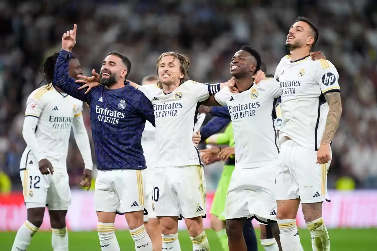 Jugadores de fútbol del Real Madrid celebrando en el campo con sonrisas y abrazos. Jugadores de fútbol del Real Madrid celebrando en el campo con sonrisas y abrazos.