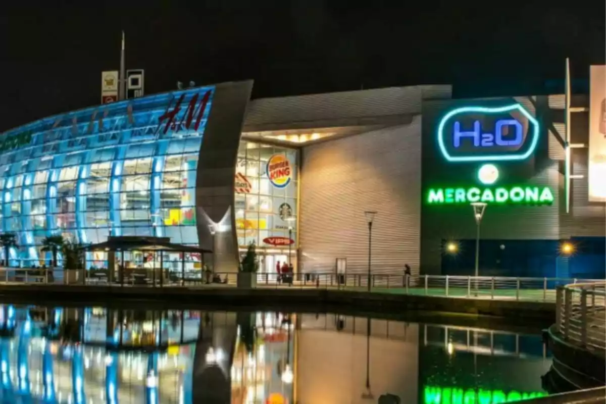 Centro comercial iluminado por la noche con reflejo en el agua. Centro comercial iluminado por la noche con reflejo en el agua.