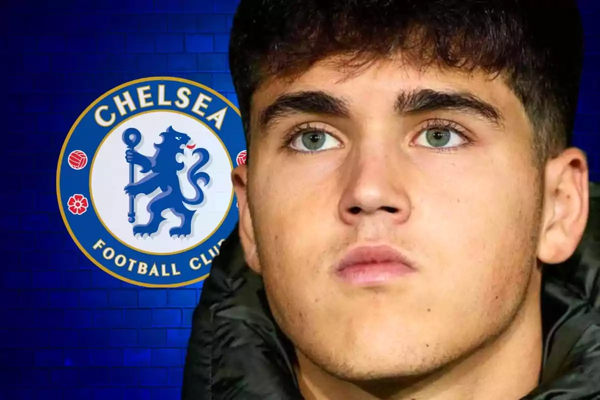 Un joven con chaqueta oscura frente al logo del Chelsea Football Club.