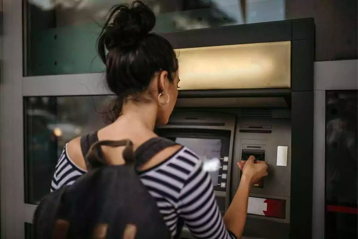 Chica sacando dinero de un cajero automático