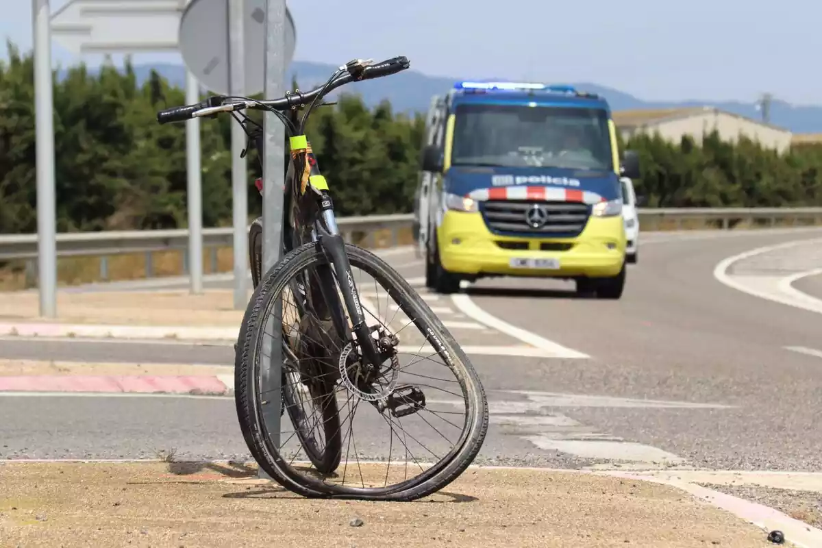 Imagen de la bicicleta accidentada con un coche de los Mossos d'Esquadra de fondo